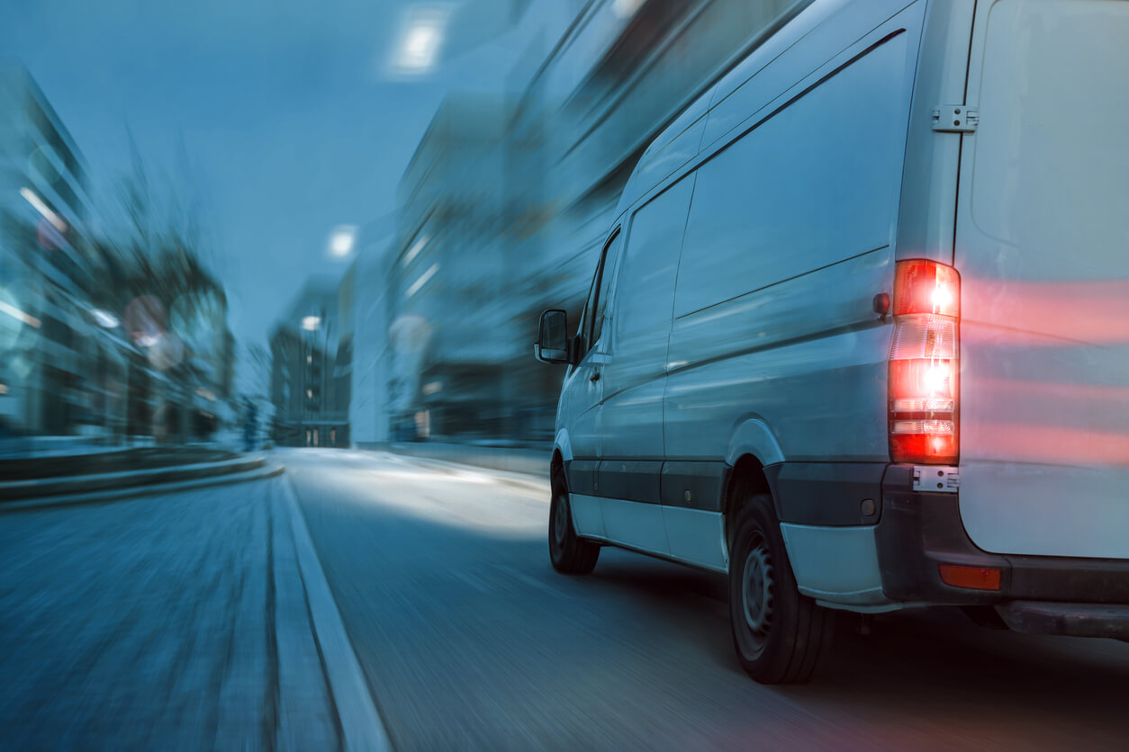 Fast delivery truck driving in the city at night